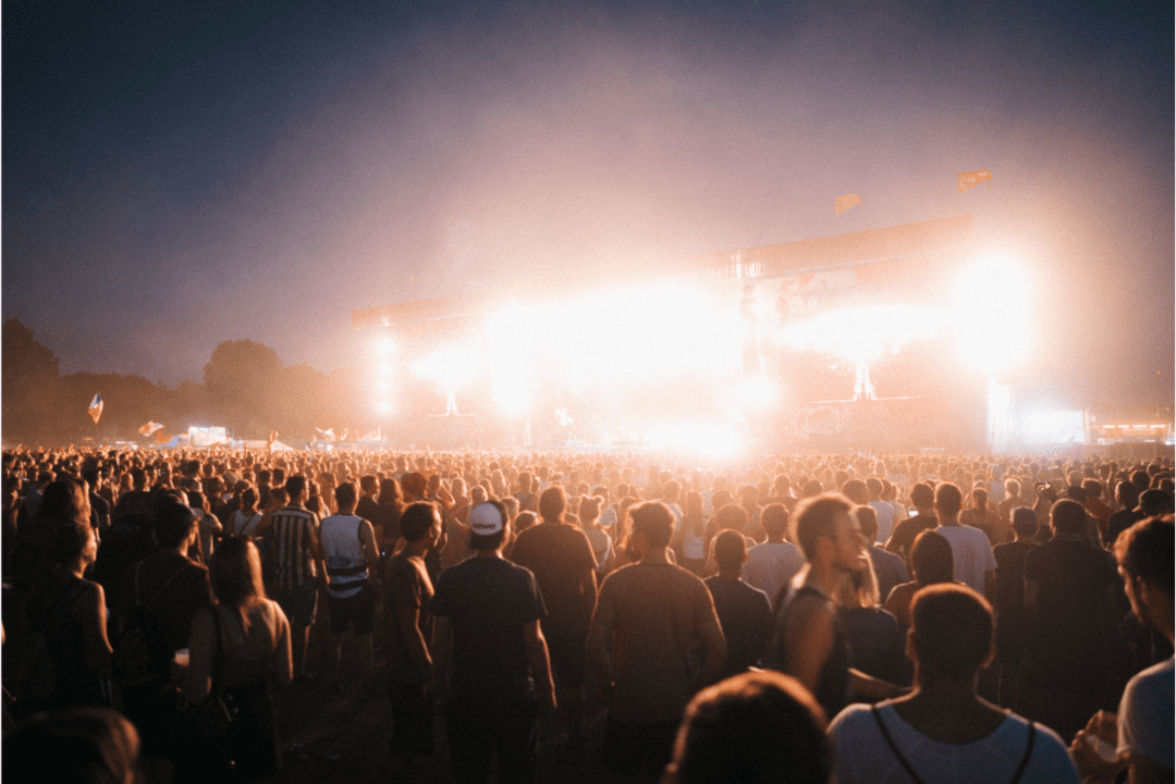 Pessoas curtindo um festival frente ao palco, como se estivessem no Rodeio de Americana.